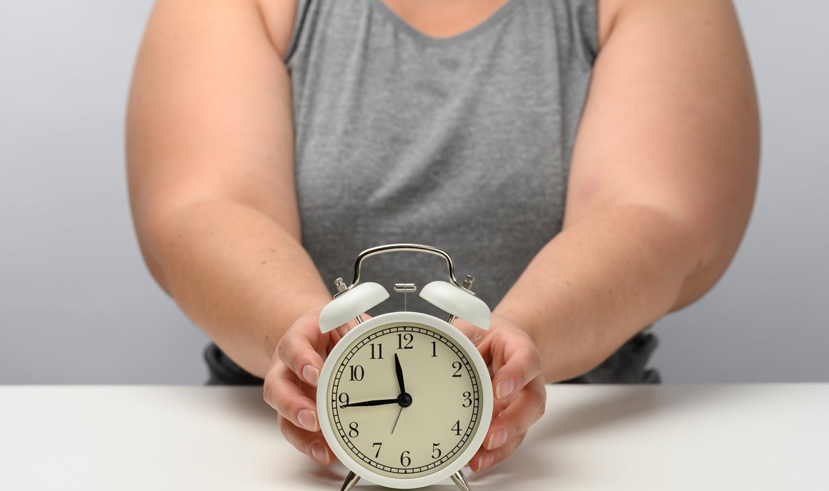 Plump,Woman,Sits,At,A,Table,And,Holds,A,Round