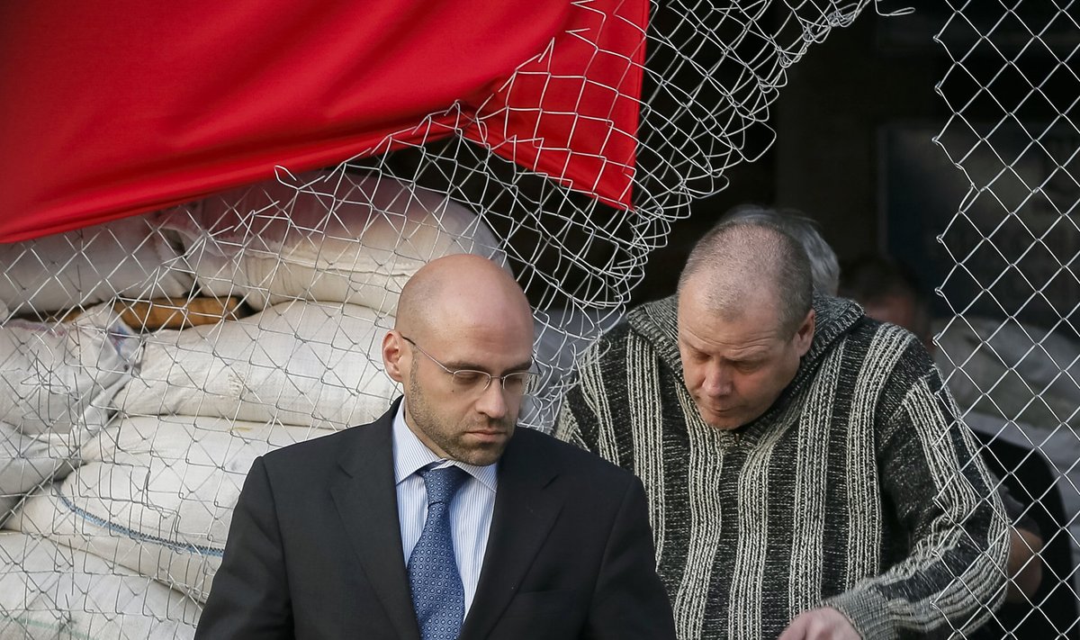 OSCE ametnik väljumas Slavjanski linnavalitsusest koos vabastatud vaatlejaga (paremal)