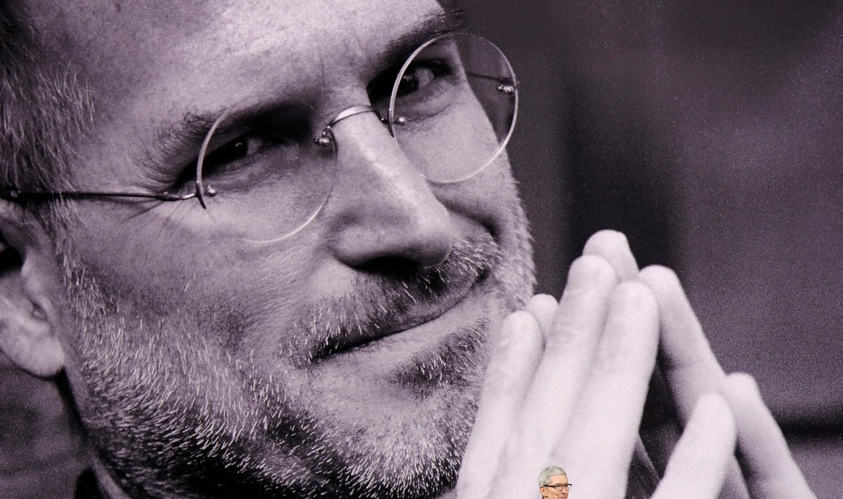 Apple juht Tim Cook endise juhi Steve Jobsi foto taustal esinemas.