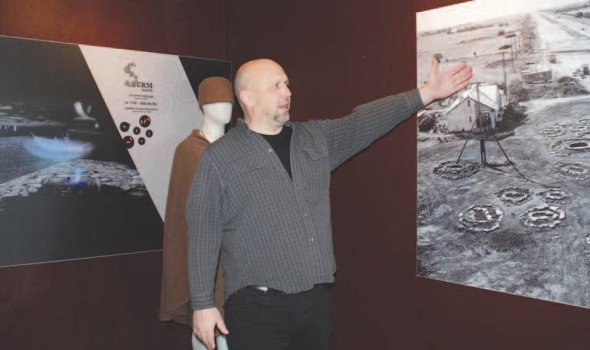 Rebala muuseumi juhataja Janek Šafranovski viitab pildile seinal. Vana Leningradi maantee ehituse käigus leiti kivikalmed. Foto: Styna Eerma