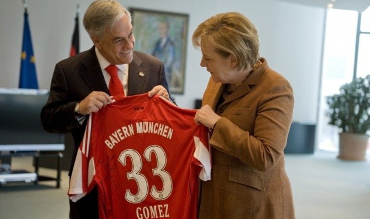 Angela Merkel annab Tšiili presidendile Sebastian Pinerale üle Saksamaa rahvuskoondislase  Mario Gomezi pühendusega jalgpallisärgi, mis kannab kaevurite pääsemisel tähelepanu saanud arvu 33.