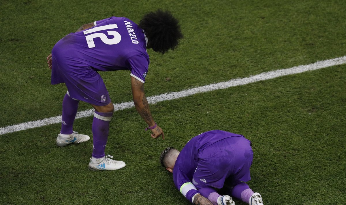 Real Madrid's Sergio Ramos holds his foot after a coming together with Juventus' Juan Cuadrado
