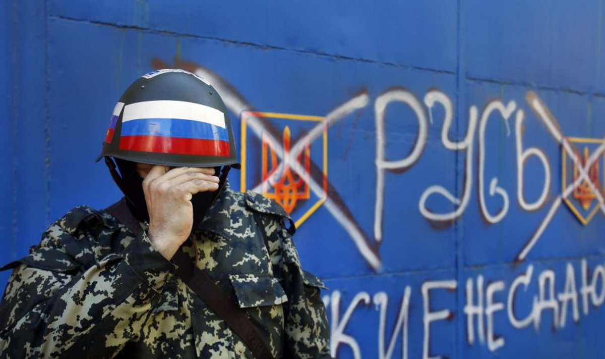 Venemeelne sõjaväelane Slovjanskis. Tekst seina peal: "Russ. Venelased ei alistu."