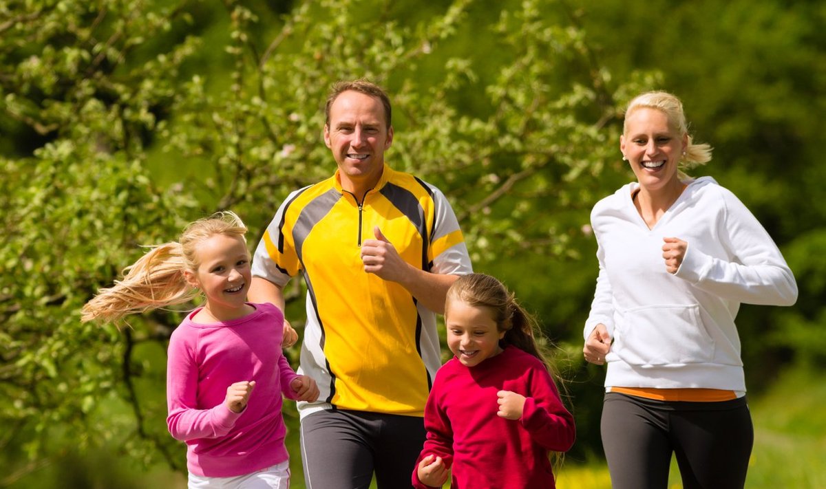 Family running in the meadow for sport