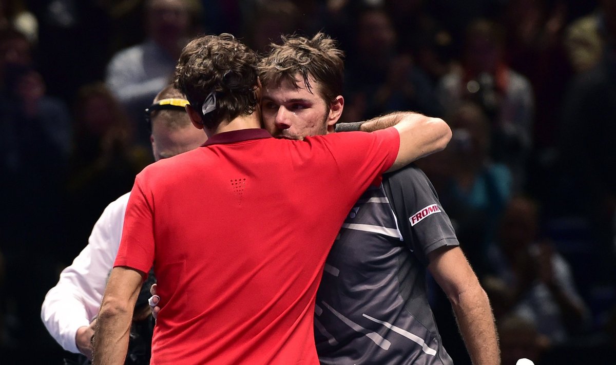 Federer embraces Wawrinka after winning semi-final tennis match at the ATP World Tour Finals at the O2 Arena in London