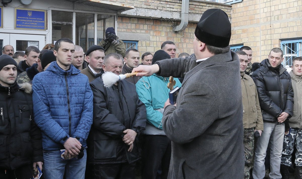 Preester pritsib Kiievis mobiliseerituid püha veega. 