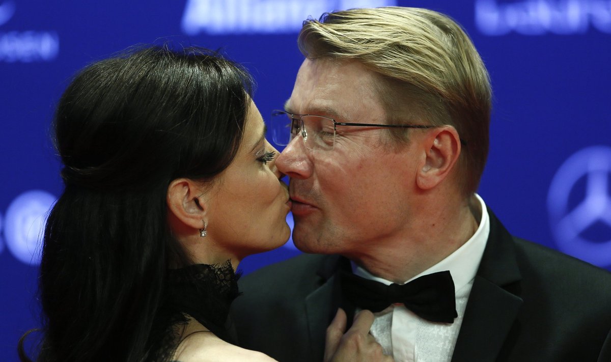 Former Formula One World Champion Hakkinen of Finland kisses a partner as they arrive for the Laureus World Sports Awards 2016 in Berlin