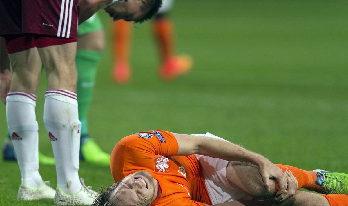 Daley Blind of the Netherlands lies injured after a challenge with Latvia's Eduards Viskanovs during their Euro 2016 Group A qualifying soccer match
