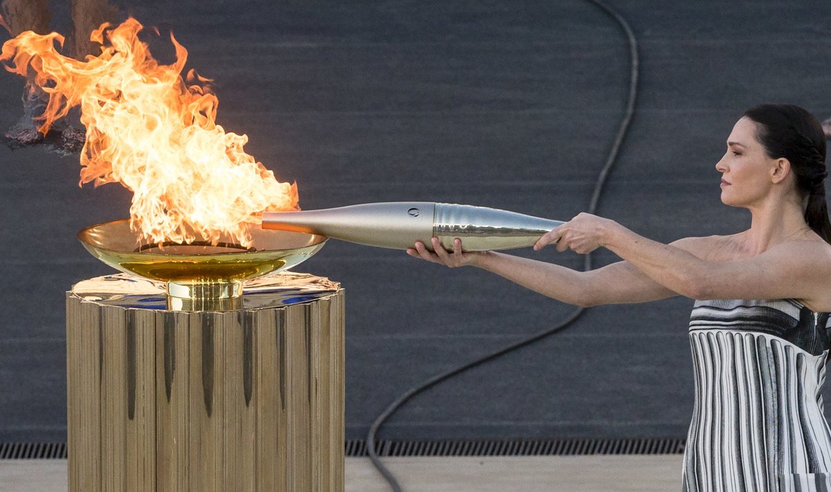 АФИНЫ, 27 апреля 2024 г. Актриса Мэри Мина, играющая роль Верховной жрицы, зажигает факел Олимпийского огня.