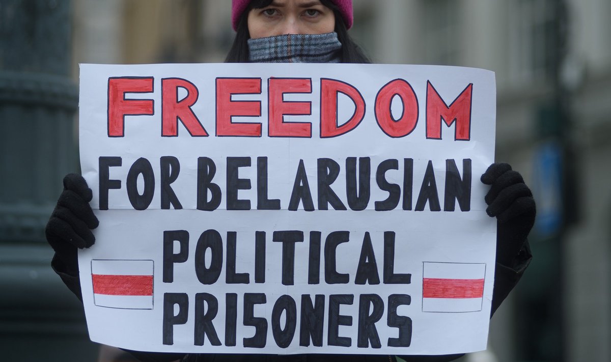Aktivist hoiab meeleavalduse ajal käes plakatit Valgevene poliitvangide toetamiseks.