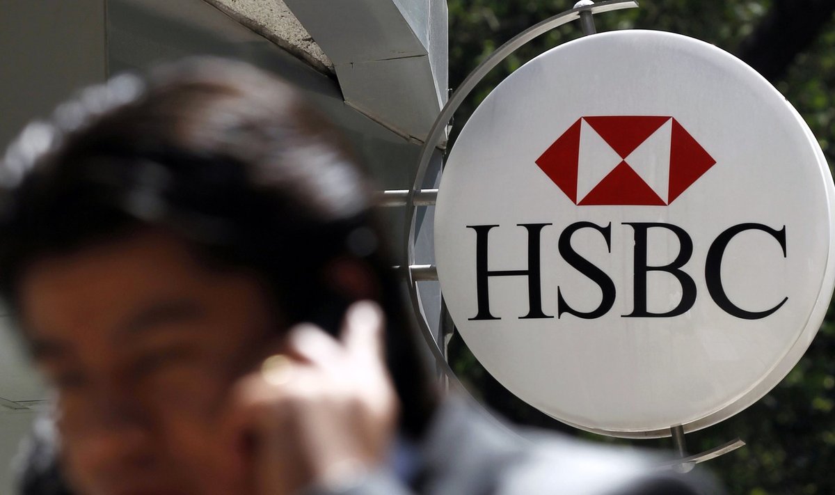 File picture shows a man talking on a mobile phone, walking past a HSBC branch office in Mexico City