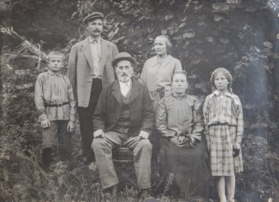 20. sajandi algus. Istub Rõugest Abhaasiasse kolinud Peeter Tinnart, tuntud ka veski rajajana. Tema kõrval istub abikaasa Miina Tinnart (snd Sprenk). Peetrist vasakul seisab poeg August Tinnart, Kati ja tema õdede vanavanaisa.