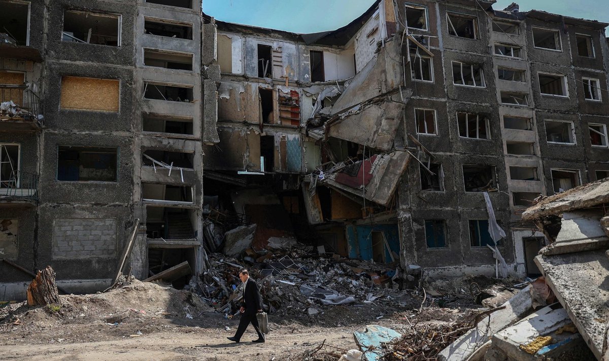 Местный житель проходит мимо сильно разрушенных зданий в городе Селидово Донецкой области 12 апреля 2024 года на фоне российского вторжения в Украину