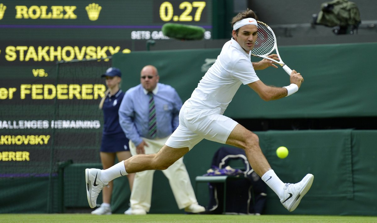 Roger Federer of Switzerland hits a return to Sergiy Stakhovsky of Ukraine in their men's singles tennis match at the Wimbledon Tennis Championships, in London