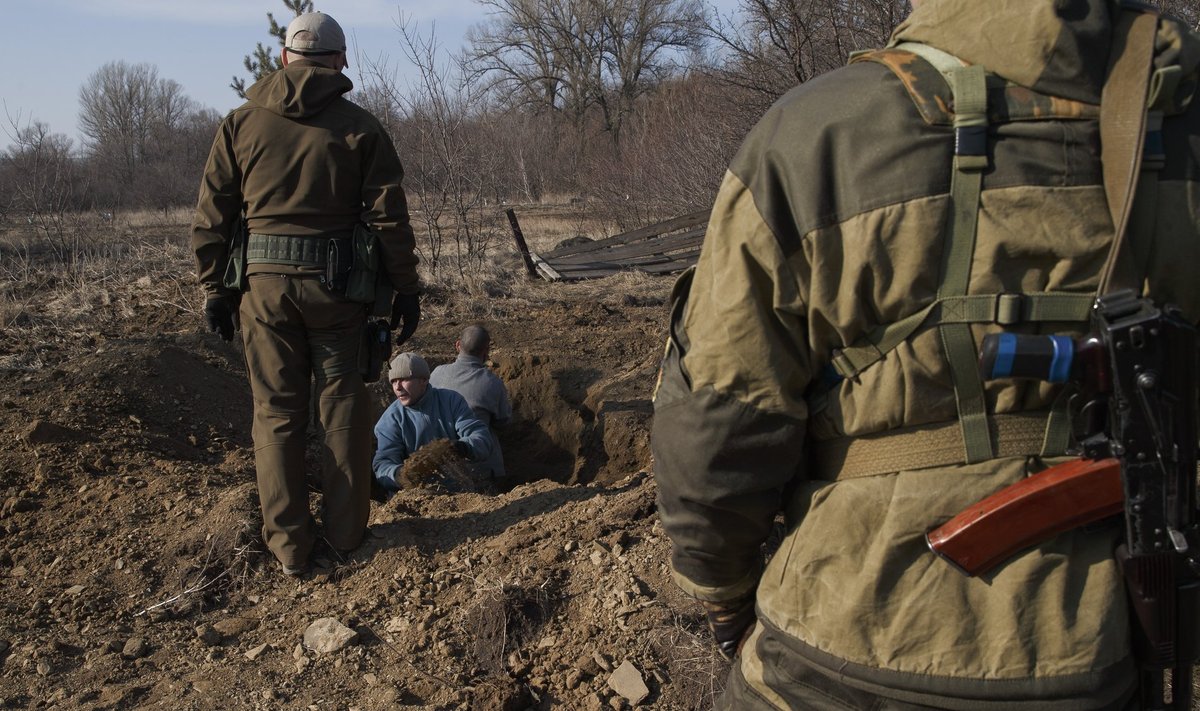 Ukraina sõjavangid kaevavad venemeelsete separatistide valve all lahti kiirkorras tehtud hauda, et surnukehad tuvastada ja sugulastele üle anda.