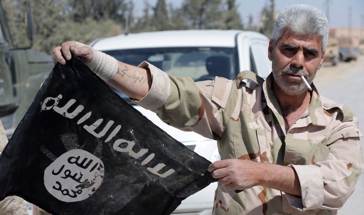 Süüria valitsusvägede sõdur Palmyras ISIS-elt trofeeks saadud lipuga