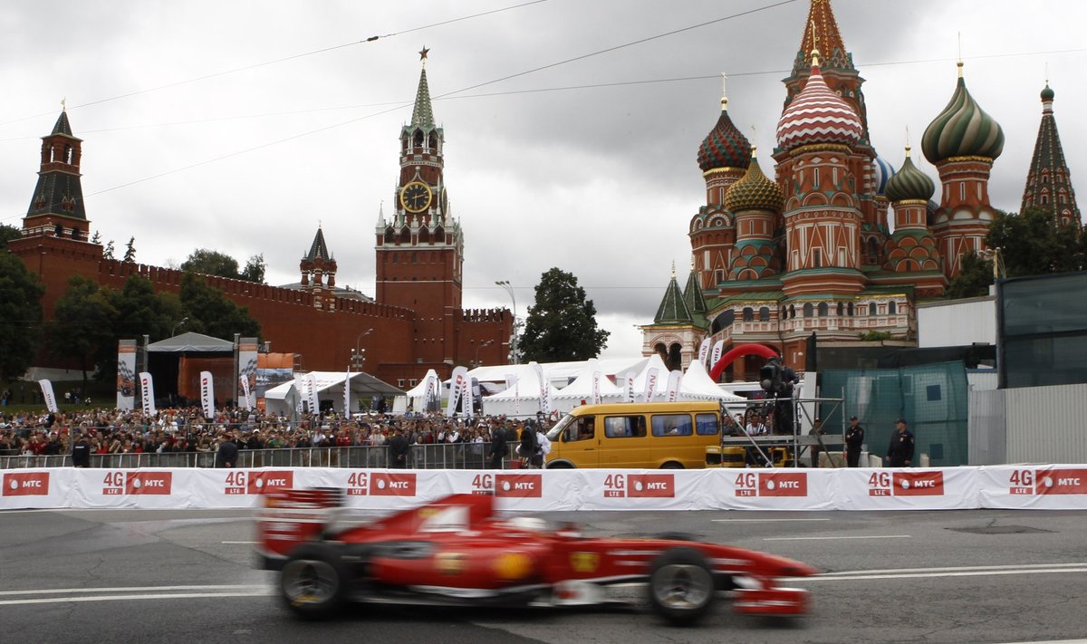 The Ferrari Formula One car piloted by Kamui Kobayashi drives past St. Basil's cathedral during the Moscow City Racing event in Moscow