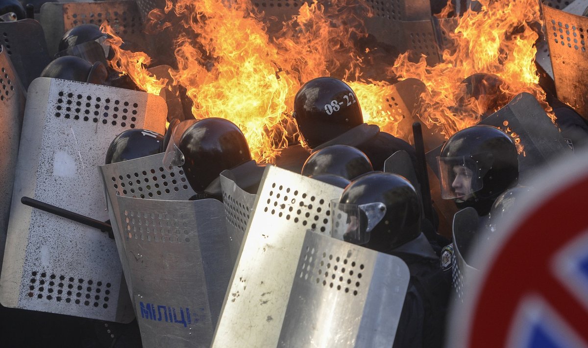 Interior Ministry members are on fire, caused by molotov cocktails hurled by anti-government protesters, as they stand guard during clashes in Kiev
