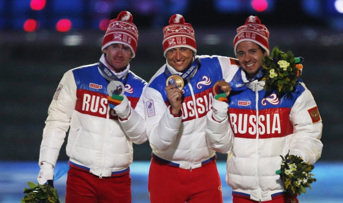 Russia's gold medallist Legkov poses with compatriots silver medallist Vylegzhanin and bronze medallist Chernousov after being presented with medals for men's cross-country 50km mass start free event during closing ceremony of Sochi Winter Olympics