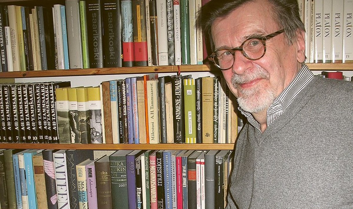 Juhani Salokannel oma raamaturiiuli ees. Tammsaare kogutud teoste kõrval (mustad raamatuseljad ülevalt kolmandal riiulil vasakul)  on näha tema tõlgitud “Tõe ja õiguse” neli köidet. Foto: Jürgen Rooste