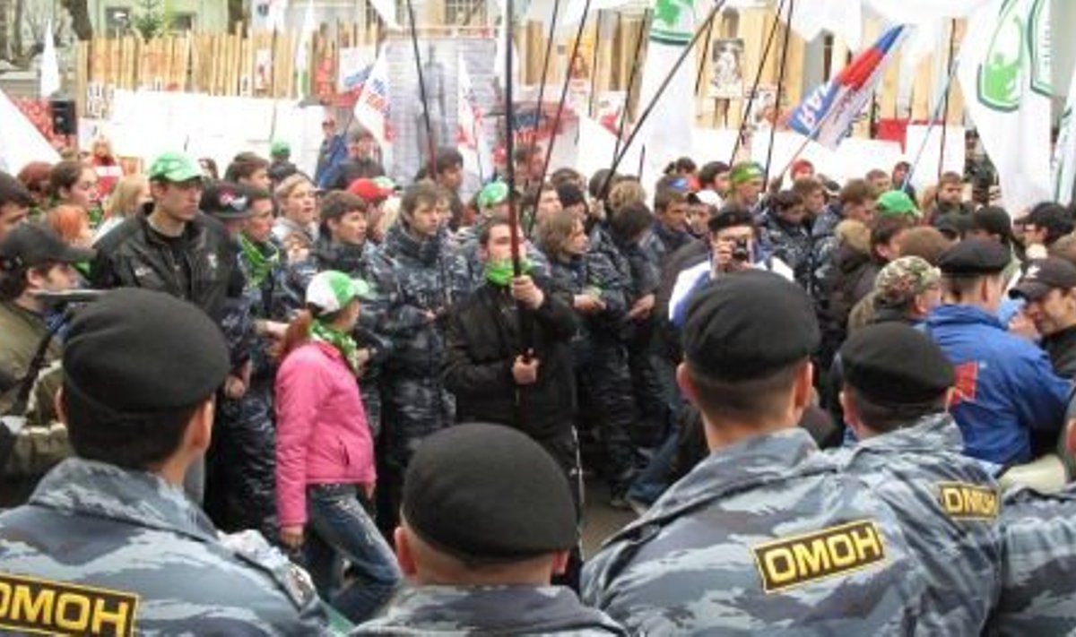 Eriüksus OMON kaitseb noorte protestijate eest Eesti suursaadiku autot, mis samal ajal saatkonna väravast sisse pöörab.