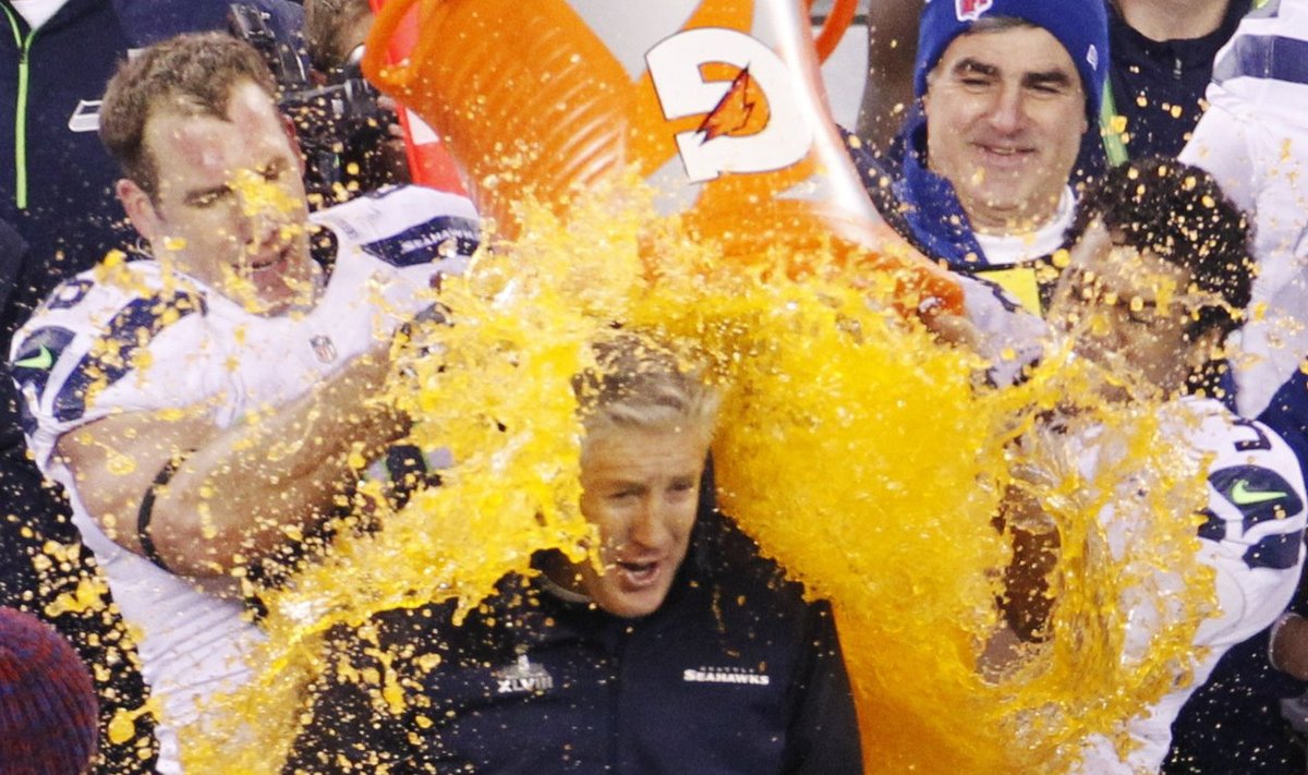 Seahawks head coach Carroll gets gatorade dumped on him in celebration by Wilson near the end of the fourth quarter against the Broncos during the NFL Super Bowl XLVIII football game in East Rutherford