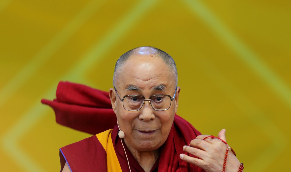 The Dalai Lama puts on his robe after speaking at the UC San Diego campus in San Diego