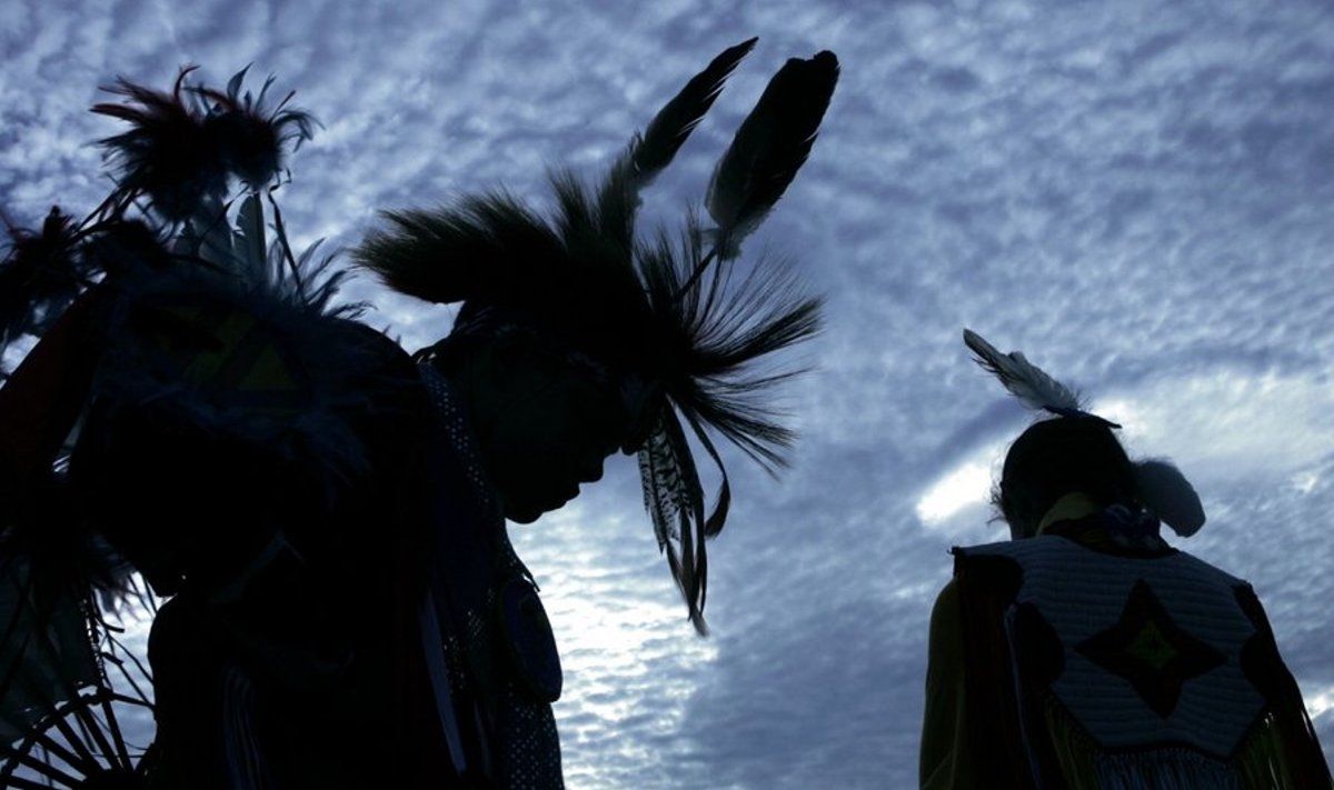 (FILES) Harrison Revels (L) and his cousin Courtney Baxter (R), members of the Lumbee Tribe in North Carolina, wait for a tribal dance on the National Mall after the grand opening of the Smithsonian's National Museum of the American Indian in this September 21, 2004 file photo in Washington, DC. The US government agreed December 8, 2009 to pay 1.4 billion dollars to settle long-running claims it mismanaged land and money it held in trust for hundreds of thousands of Native Americans.President Barack Obama praised the settlement as "an important step towards a sincere reconciliation" between the federal government and some 300,000 beneficiaries of the lawsuits.The agreement must be approved by the US Congress and the US district court of the District of Columbia, but if confirmed it would conclude a bitter class action suit first brought in 1996 by Elouise Cobell.  AFP PHOTO/Brendan SMIALOWSKI