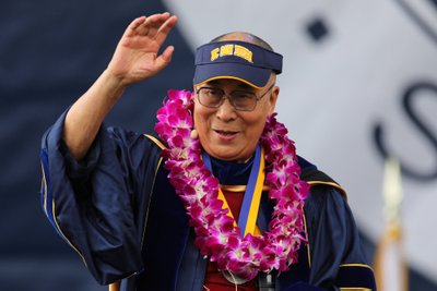 The 14th Dalai Lama is given a school hat before delivering the commencement speech to the 2017 graduating class at UC San Diego in San Diego