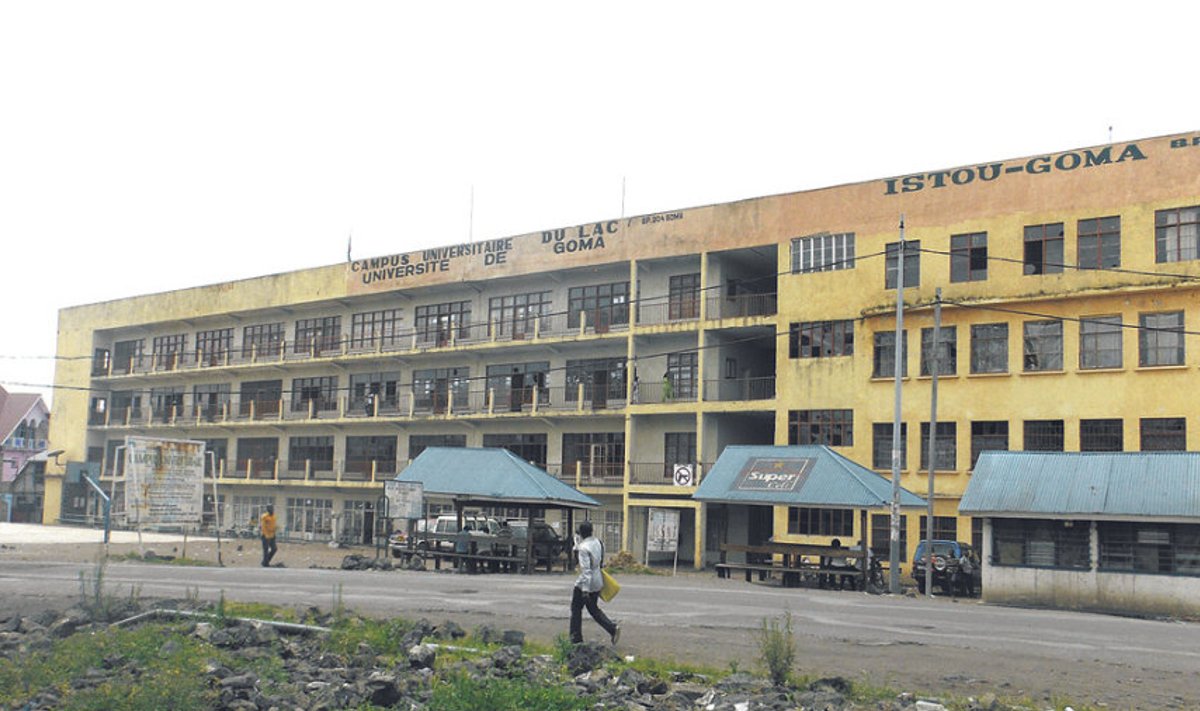 Selline ongi Goma ülikool –  katkiste akendega neljakorruseline  betoonhoone, mille rõdupiirdele  kinnitatud sildist võib järeldada,  et relvad on koolis keelatud. 