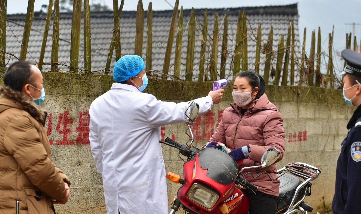 ABIMEETMED: Meditsiinitöötaja kontrollib Dangjiu küla elaniku kehatemperatuuri.