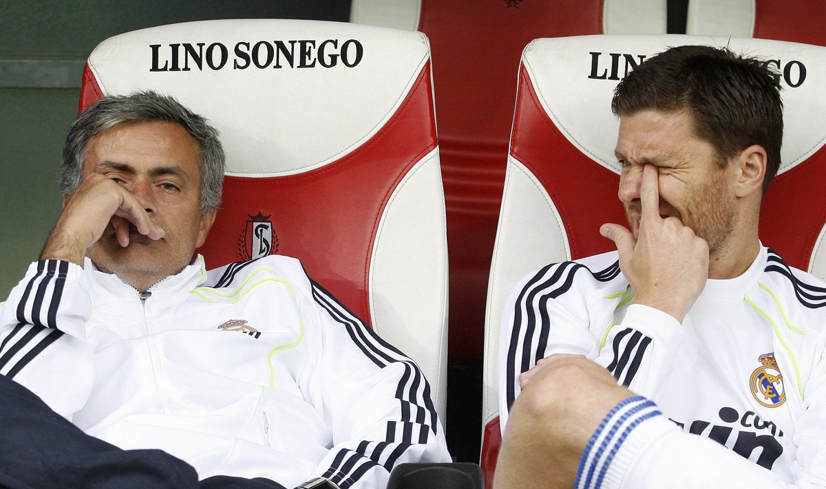 Real Madrid's coach Mourinho and midfielder Xabi sit before their friendly soccer match against Standard Liege in Liege