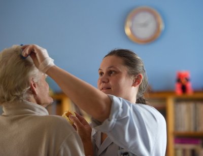 Igal hommikul tegeletakse hoolealuste isikliku hügieeniga: kammitakse juukseid, aetakse habemeid, lõigatakse küüsi ja viiakse duši alla. Pildil kammib patsiendi juukseid Anne Altmäe - hooldustöötaja, teeb seda tööd juba veebruarist 2009.