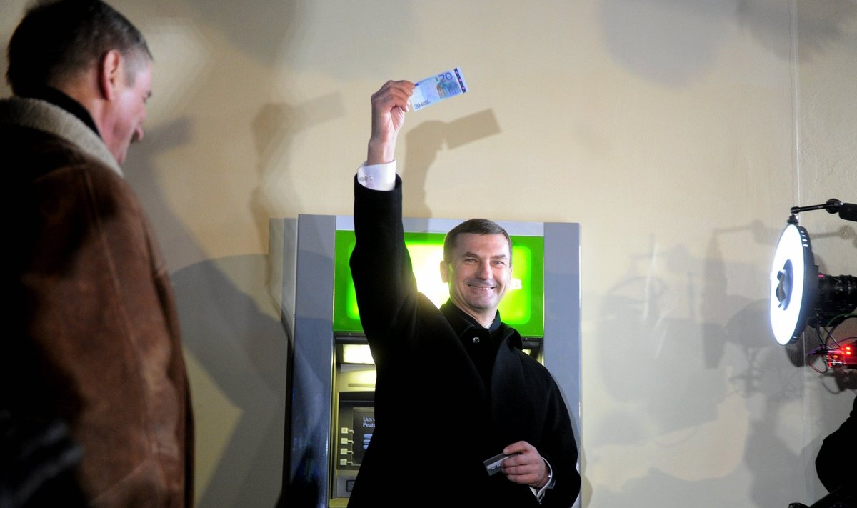 Võidukas peaminister Andrus Ansip 2011. aasta esimestel minutitel. Sularahaautomaat andis välja esimesed eurod.