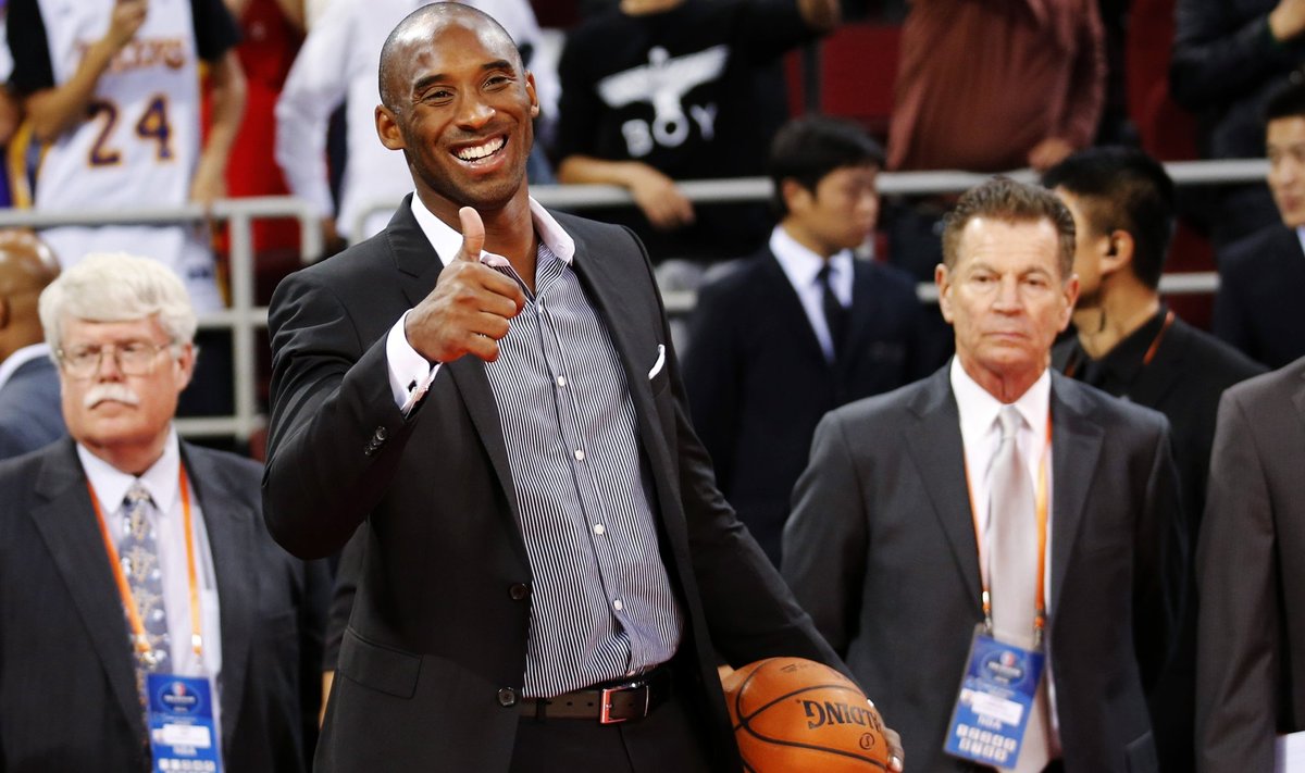 Los Angeles Lakers' Bryant gestures to his teammates before their game against the Golden State Warriors at the NBA Global Games in Beijing