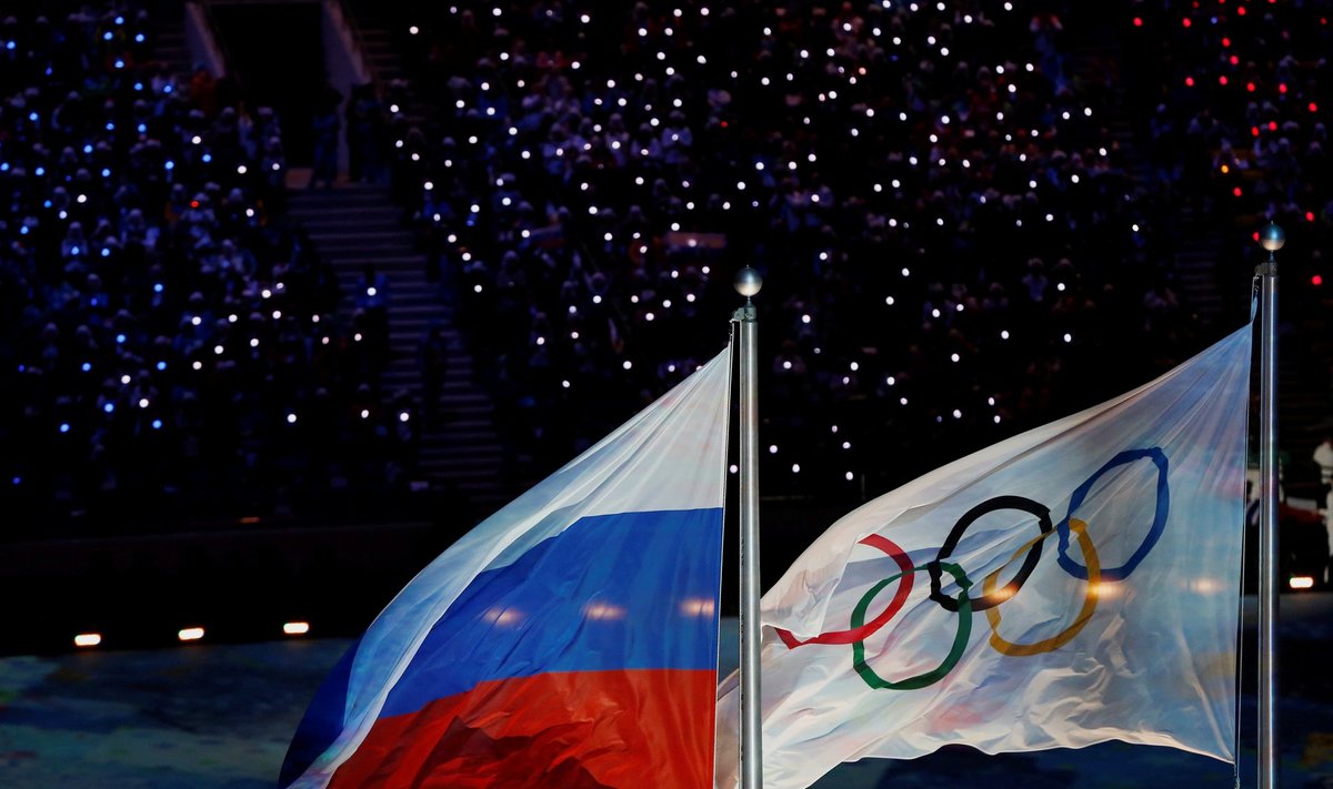 Russian national flag flutters next to Olympics flag during closing ceremony for 2014 Sochi Winter Olympics