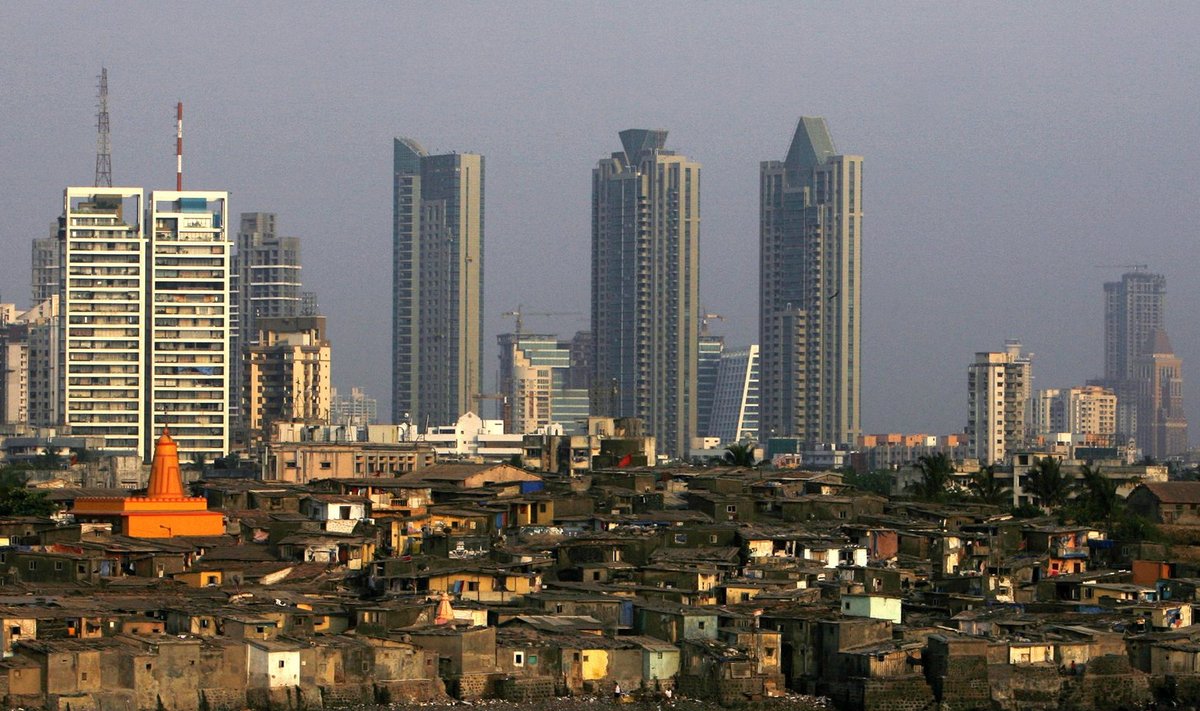 High rise buildings are seen behind a slum in Mumbai