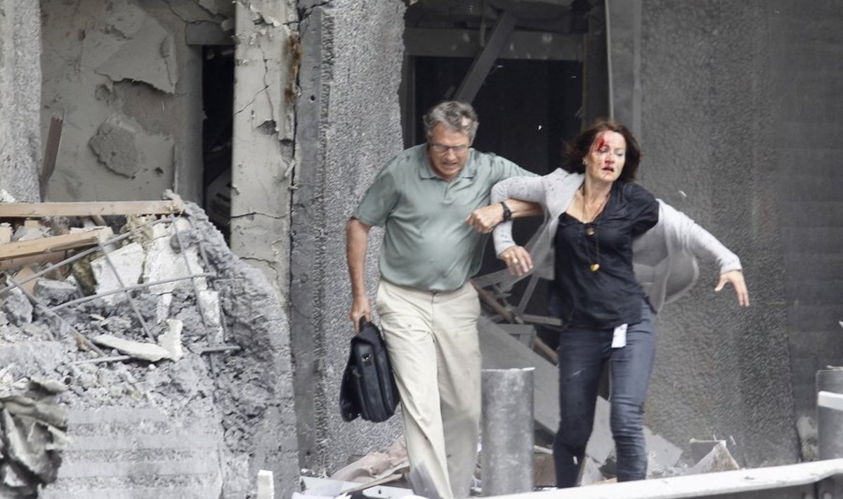 Mees aitab pärast pommiplahvatust Oslos vigastada saanud naisel majast väljuda