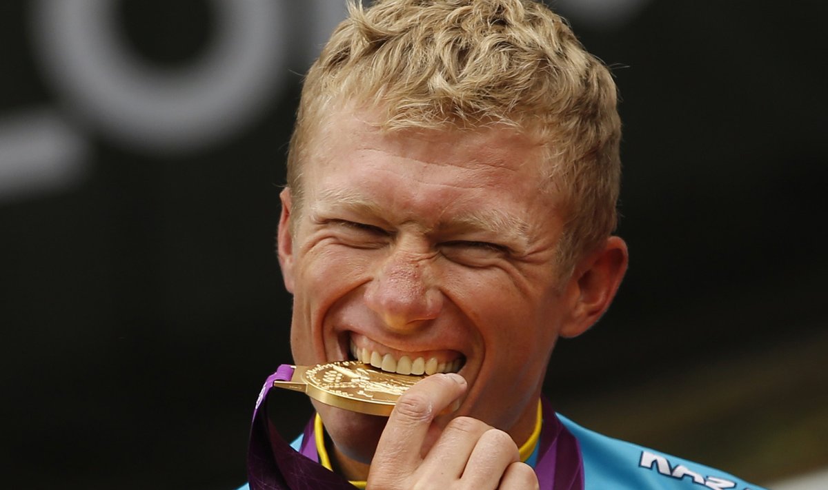 Kazakhstan's Alexandr Vinokurov bites his gold medal during the victory ceremony after the men's cycling road race at the London 2012 Olympic Games