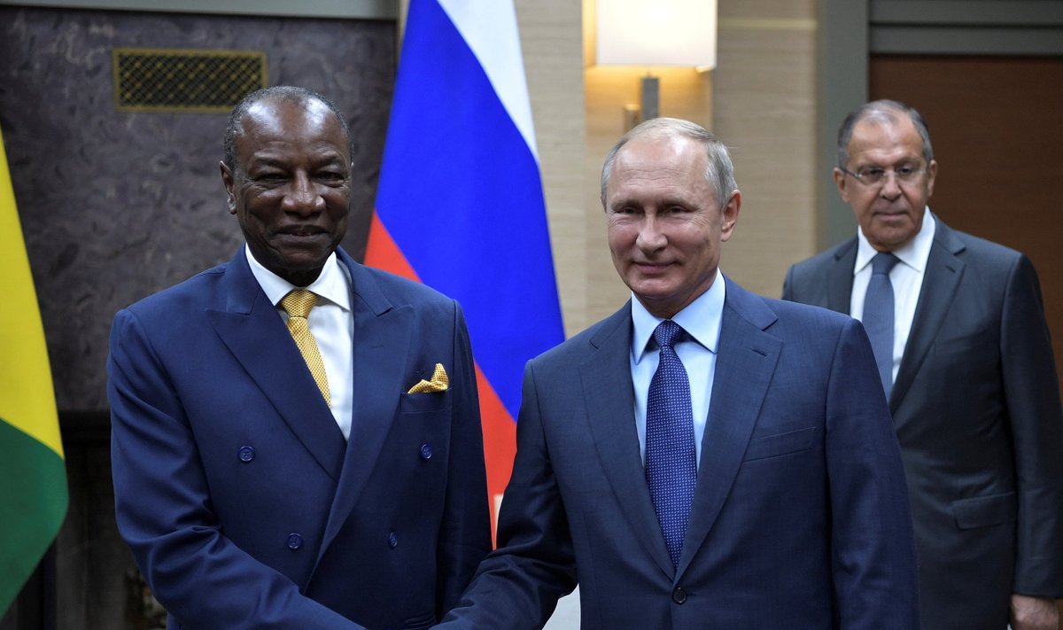 Russian President Vladimir Putin shakes hands with Guinea President Alpha Conde, with Foreign Minister Sergei Lavrov seen nearby, during a meeting at the Novo-Ogaryovo state residence outside Moscow