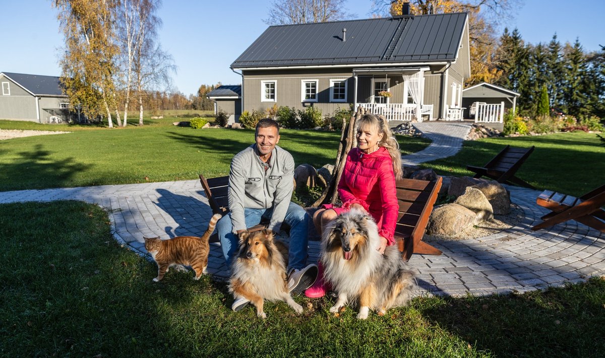 Mart ja Maila koos pere neljajalgsete liikmetega lõkkekohas, taustale jääb elumaja ja vasakule kanala.