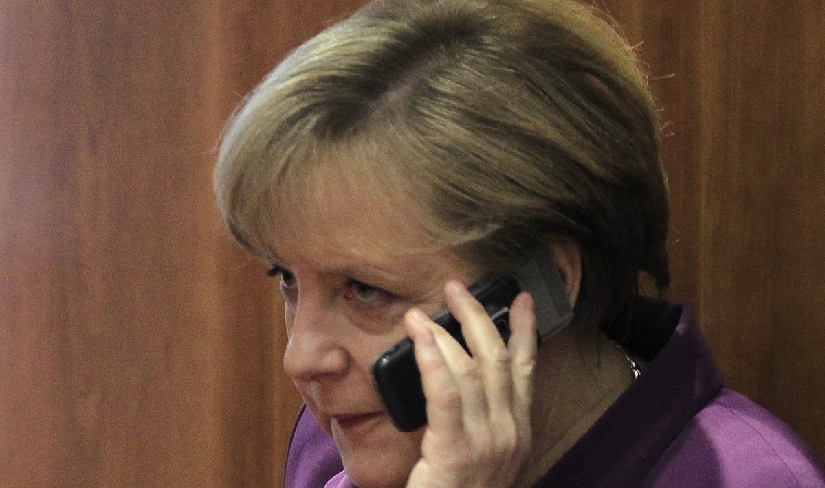 File photo of Germany's Chancellor Merkel using her mobile phone before a meeting at a European Union summit in Brussels
