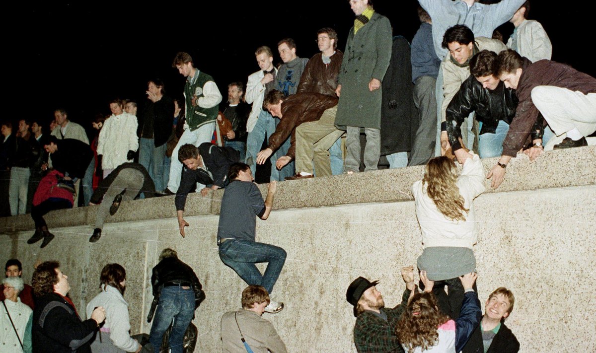 Ida- ja Lääne-Saksamaa kodanikud ronivad Berliini müürile tähistama Brandenburgi väravate avamist 9. novembril 1989. aastal.