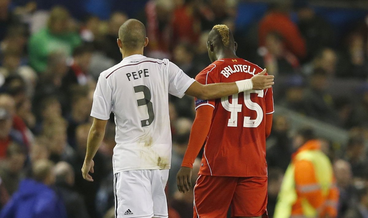 Liverpool's Mario Balotelli walks off the pitch at half-time with Real Madrid's Pepe, before swapping shirts in the tunnel, during their Champions League Group B soccer match at Anfield in Liverpool
