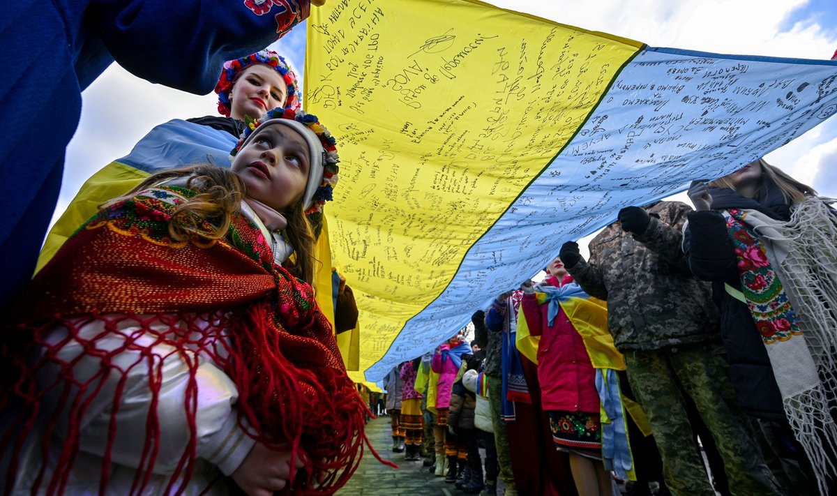 LVIVIS: Ukraina tüdruk pikima Ukraina lipuga, millele on kirjutatud head soovid sõjaväele.