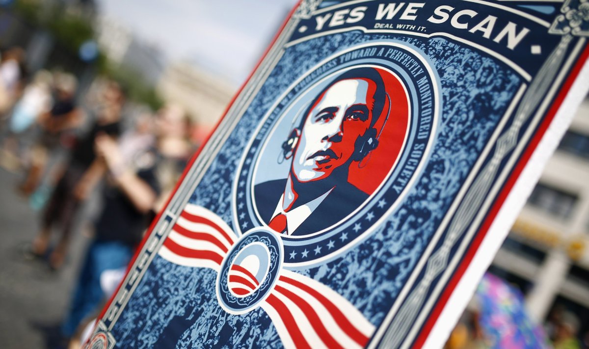 A protester holds placard showing U.S. President Obama during demonstration against NSA and in support of Snowden in Frankfurt