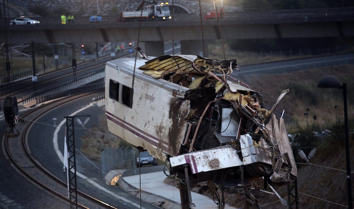A crane removes a carriage from the tracks at the site of a train crash near Santiago de Compostela