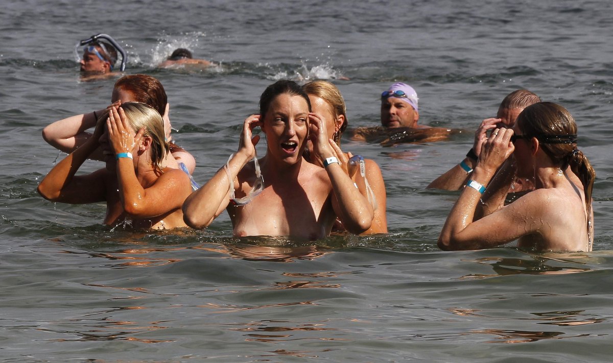 People participate in the "Sydney Skinny", a 900m nude swim, at Clobbers beach in Sydney