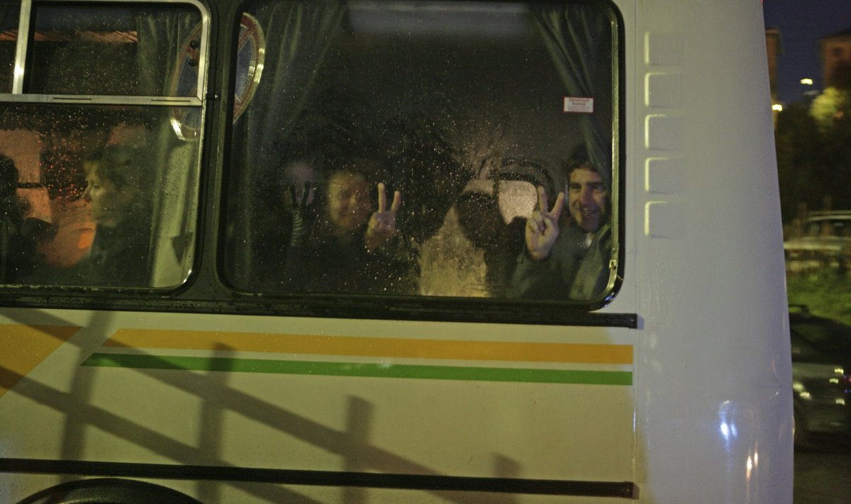 Handout photo of crew members of the ship Arctic Sunrise and Greenpeace activists seen through a bus window while being escorted to the offices of the Russian Investigative Committee in Murmansk