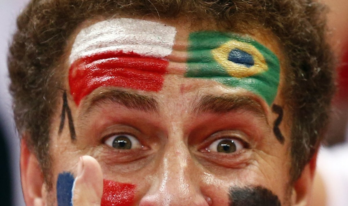 A supporter with his face painted with the flags of Poland, Brazil, France and Germany cheers during their final match between Brazil and Poland at the FIVB Volleyball Men's World Championship Poland 2014 in Katowice